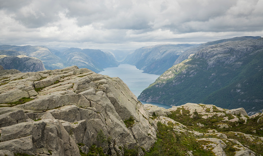 View on the Lysefjord surrounded by norwegian mountains under a cloudy sky