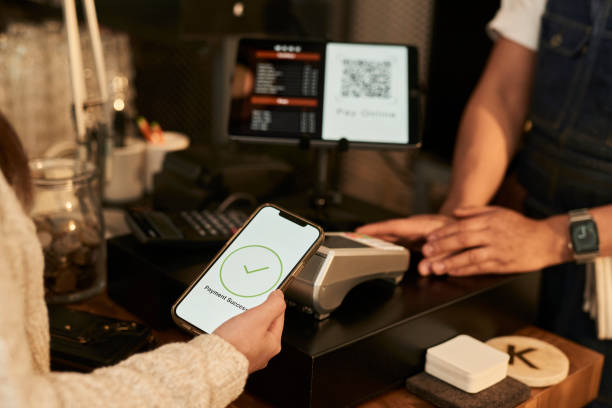 istock Customer using smart phone to pay online with a QR code to owner at coffee shop, E-commerce concept stock concept stock 1467546619