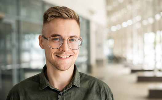 Cheerful caucasian young man entrepreneur in office building close-up