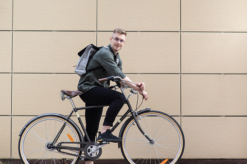 Smiling man riding a bike outdoor. Travel, people and active lifestyle concept