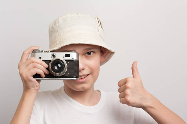 A boy photographs flowers with a SLR camera in the summer garden