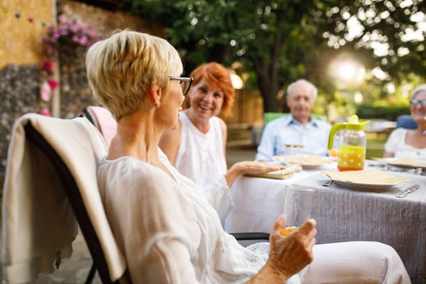 istock Cheerful elderly couple enjoying drinks and snacks at garden party 1467558949