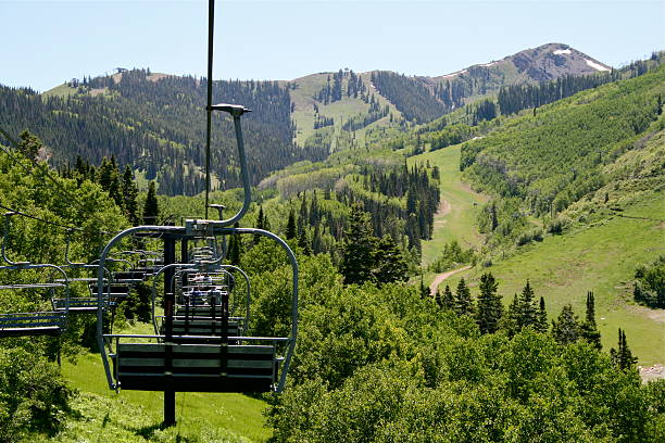 This chairlift carries summer sightseers up the Wasatch Mountain Range in Park City, Utah. Selective focus on 1st chair. Lots of copy space to right.