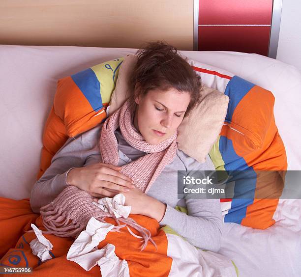 Woman Lying In Bed Asleep With Used Tissues Around Her Stock Photo - Download Image Now