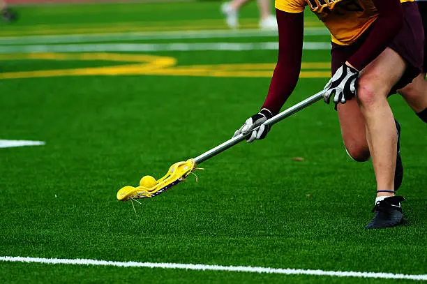 Womens lacrosse player scooping up the ball for a turn over.