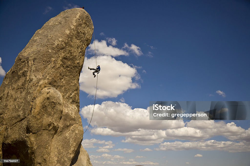 Rock climber Discesa a corda doppia. - Foto stock royalty-free di A mezz'aria