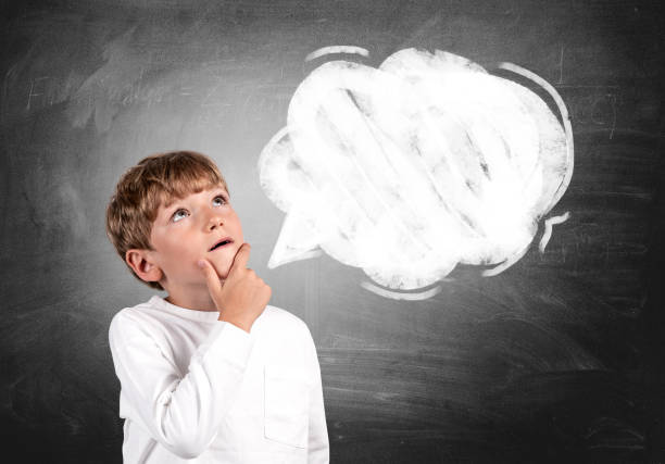 istock Pensive kid boy portrait looking up, chalkboard with empty speech bubble 1467560817