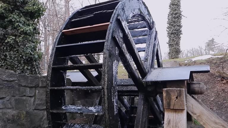 Slow motion of water mill wheel with falling drops.