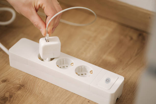 istock Human hand puts cable into the charger. Extension cord. White cable connector 1467571059