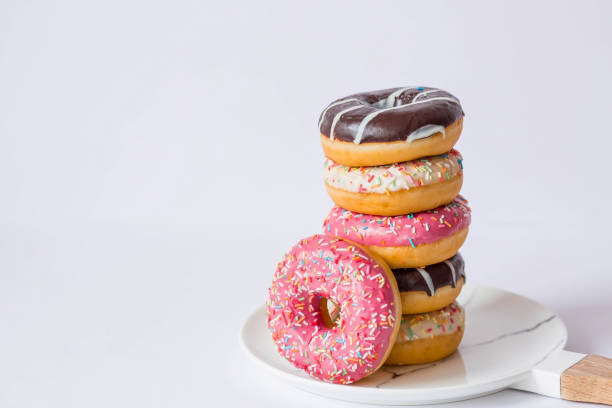 istock Delicious dessert. Pink, white and chocolate donuts with multicolored sprinkles on a white background of Sweets. Confectionery products. 1467576539