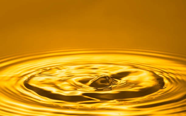 istock Golden oil splash on surface background. 1467577004
