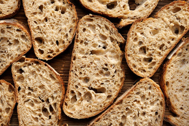 Fatias de pão de massa no fundo de madeira, vista superior. - foto de acervo