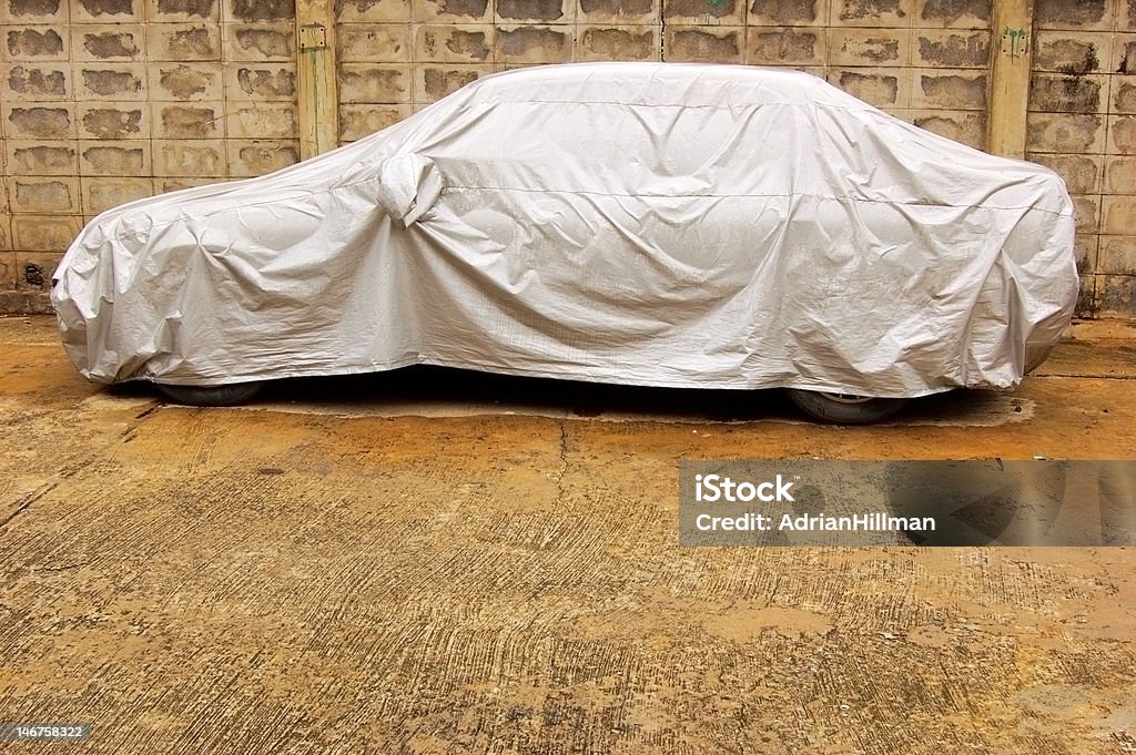 Covered car A parked car with protective cover in wet weather Covering Stock Photo