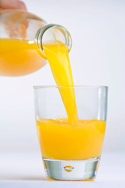 istock hand bottle pouring orange juice on a glass 146758379