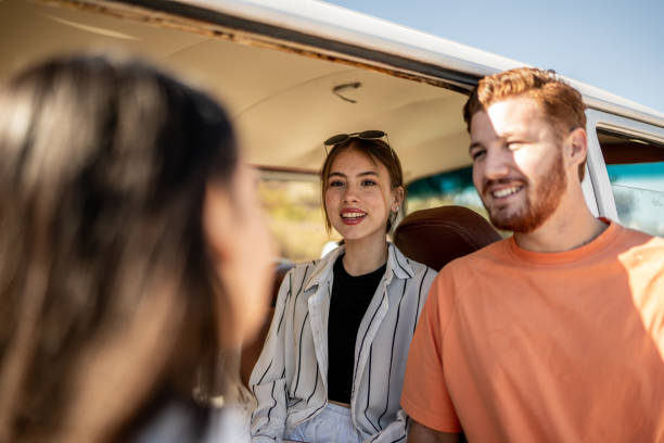 istock Group of young friends talking inside a mini van 1467584448