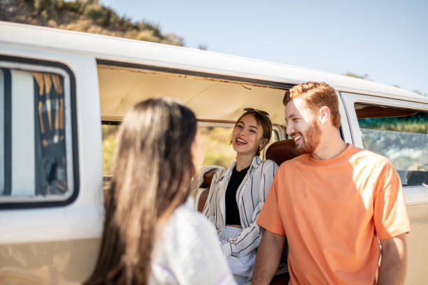 Group of young friends talking inside a mini van