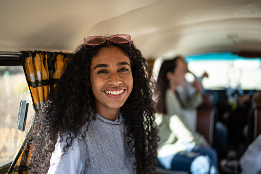 Portrait of young woman on a road trip inside a mini van