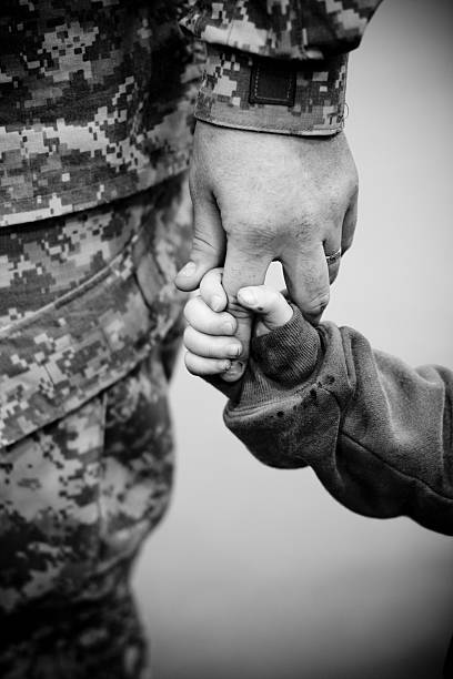 Hero and son Camera Canon 40 D, 50 mm 1.4 lens, picture was taken in a gym during re-deployment ceremony after the soldiers were released to their families. military deployment photos stock pictures, royalty-free photos & images