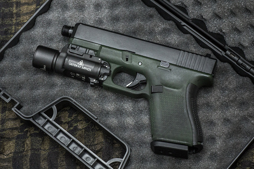 Glock 19 gen4 and gen5 model, Glock polymer pistol and popular handgun weapon with flashlight attachment olive green color and black.