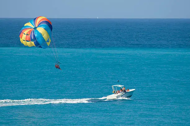 Vacationers try out the water sport of parasailing