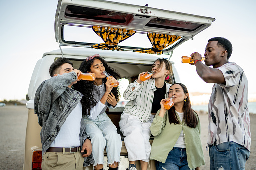 Group of young friends drinking soda outdoors