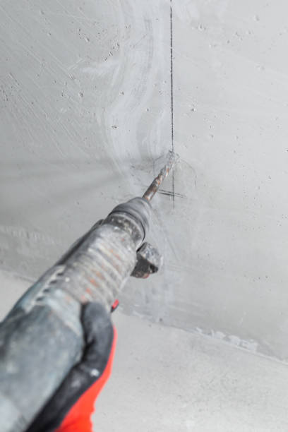 istock Chasing an installation channel in a concrete wall with an impact drill and attachments 1467589619