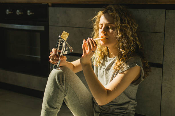 istock Woman eating chips in the kitchen 1467592074