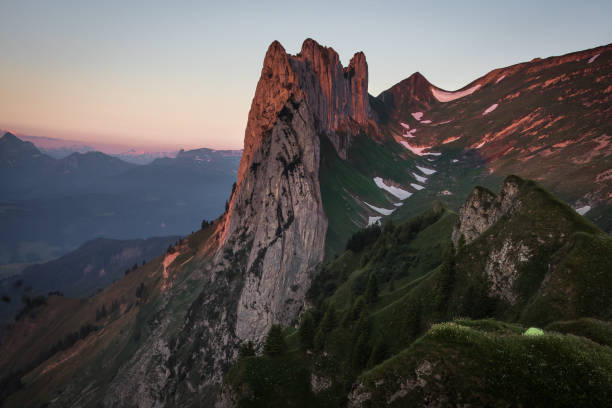 스위스의 saxer lücke에서 숨막히는 산의 전망을 감상할 수 있으며, 등산객들이 인상적인 일출과 빛나는 산봉우리를 보기 위해 밤을 보낸 작은 텐트가 있습니다. - alpenglow 뉴스 사진 이미지