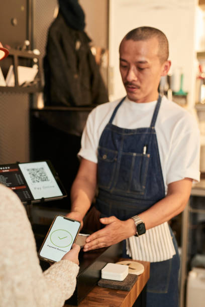 istock Customer using smart phone to pay online with a QR code to owner at coffee shop, E-commerce concept stock 1467594899