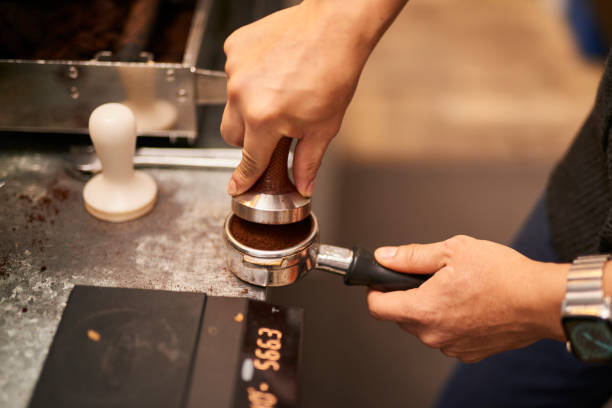 istock Young Asian barista tamping fresh ground coffee. 1467596116