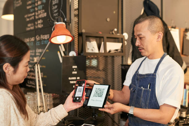 istock Customer using smart phone to pay online with a QR code to owner at coffee shop, E-commerce concept stock 1467596703