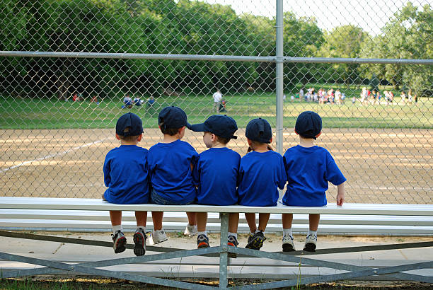 baseball bench warmers five little boys sit on the bench waiting for their baseball / tball game to begin youth baseball and softball league photos stock pictures, royalty-free photos & images