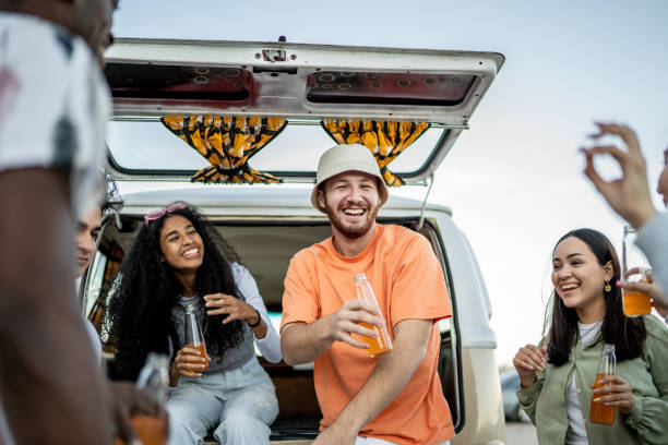 istock Young friends having a celebration on retro mini van transport 1467598996