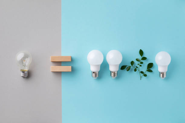 istock Modern led lights with green leaves energy saving eco concept against incandescent lightbulbs top view. Power efficiency and nature protection. 1467599574