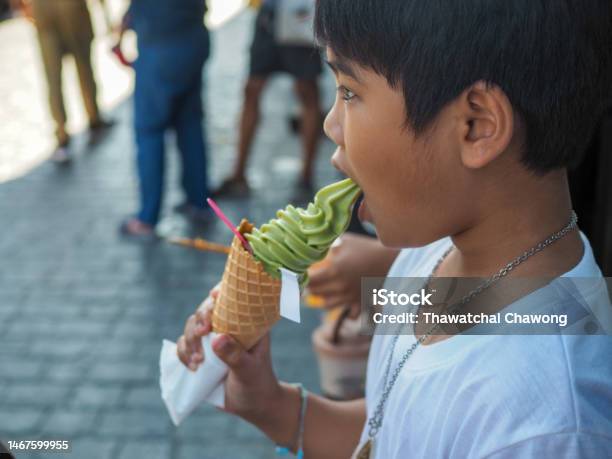 A Boy Wearing A White Shirt Is Eating Ice Cream Stock Photo