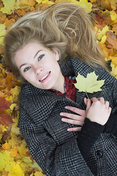Beautiful young woman and autumn background with color leaves stock photo