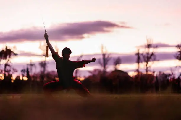 Photo of martial arts mid latin woman wushu kung-fu sword. healthy wellness active training. argentinean.