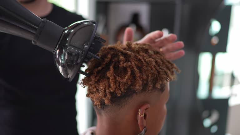 Hairdresser blow drying a woman's hair at the hair salon