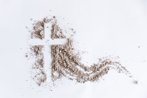 Christian cross or crucifix drawing in ash, dust or sand as symbol of religion, sacrifice, redemption, Jesus Christ, ash wednesday, lent, Good Friday, Easter with Church is devoted to fasting