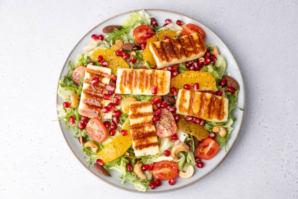 istock Warm salad with roasted halloumi cheese, nuts (cashews and almonds), cherry tomatoes, pomegranate, orange and arugula. Traditional oriental cheese 1467611169