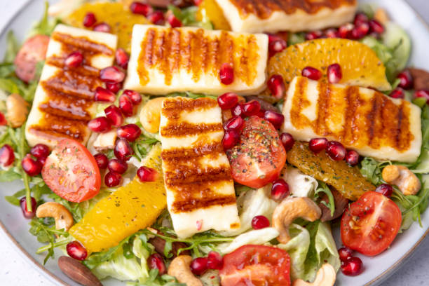 istock Warm salad with roasted halloumi cheese, nuts (cashews and almonds), cherry tomatoes, pomegranate, orange and arugula. Traditional oriental cheese 1467611203
