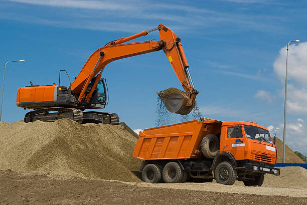 Excavator and dump truck stock photo