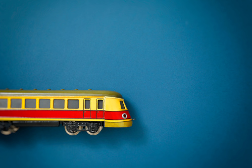 Yellow toy railcar from the 1940s on blue background cardboard