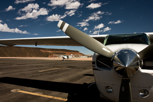 General aviation airplane on the tarmac in Utah with a blue sky and clouds in the background.