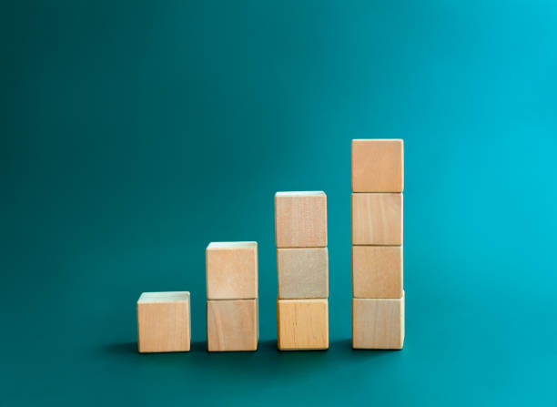 istock Blank wooden cube blocks bar graph chart steps, isolated on dark blue background, investment, income, trends, inflation, business growth, economic improvement concepts. Four step eco style wood graph. 1467617769