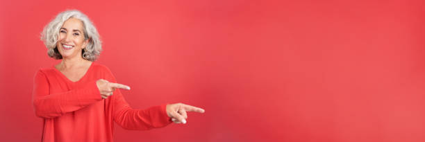 istock Smiley mature woman pointing to the side 1467624022