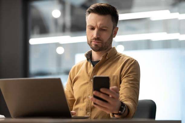 istock Businessman Texting On Phone Reading Negative Message Working In Office 1467628288