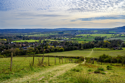 A panoramic aerial image over a rolling landscape of fields separated by traditional hedgerows and small woodland, in the English Midlands.