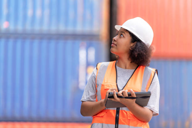 istock African American dock manager in uniform and safety helmet working and inspector at container cargo with digital tablet. Logistics import and export shipping yard. Transportation and global business concept 1467631239