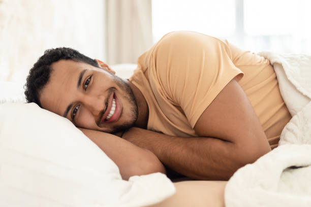 istock Arabic Guy Lying In Bed Smiling To Camera In Bedroom 1467632120